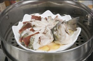 將鱸魚成花狀擺好，將火腿切片放入各縫隙中，放入鍋中隔水蒸12分鐘拿出，撒上蔥花即可。