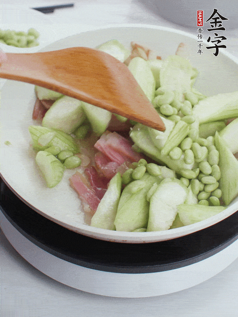 依次下絲瓜、青豆翻炒，炒至絲瓜打蔫縮小。