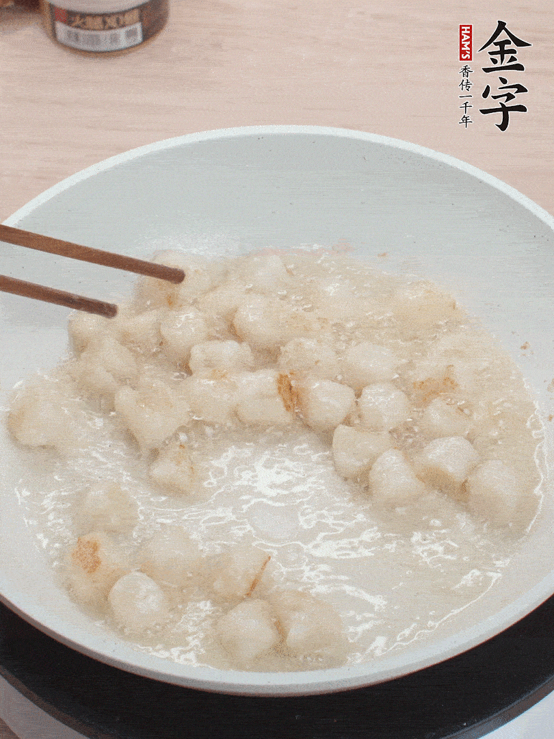 油溫4成熱，鮮貝蘸干淀粉下鍋煎，一面微黃后翻面。