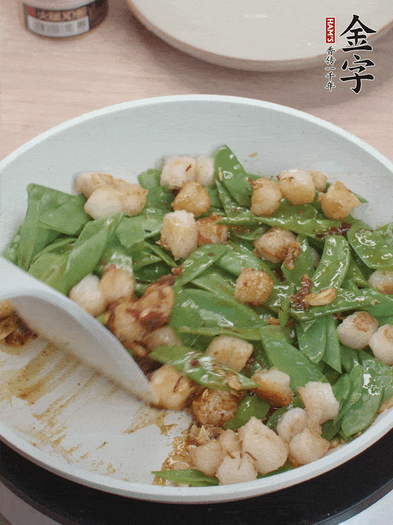 下甜豆莢、鮮貝輕輕翻炒均勻。