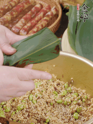 粽葉往下折，完全蓋住，兩側(cè)捏緊。