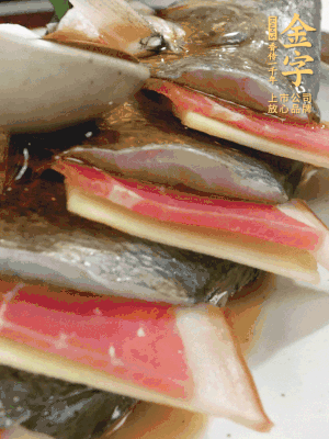 魚肚中塞蔥結(jié)、火腿片，魚身上碼放姜片、火腿片，倒入混合的料汁。