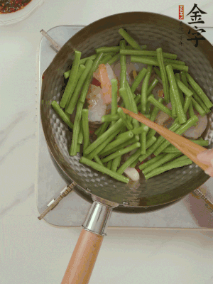 下掰好的缸豆段翻炒，略燜煮。