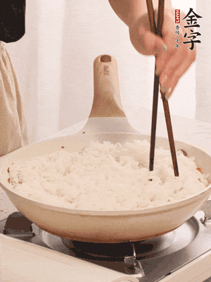 把瀝干水分的米飯均勻鋪在上面，筷子戳幾個(gè)洞，以便透氣，轉(zhuǎn)小火蓋上蓋子燜至水分收干，大概10分鐘。